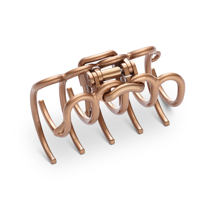 Detailansicht der elastischen Zähne und bronzefarbenen Oberfläche der großen Haarklammer